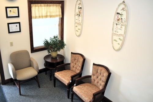 The clinic lobby, containing two chairs and a set of paintings, as well as Dr. Fu's medical certificates.